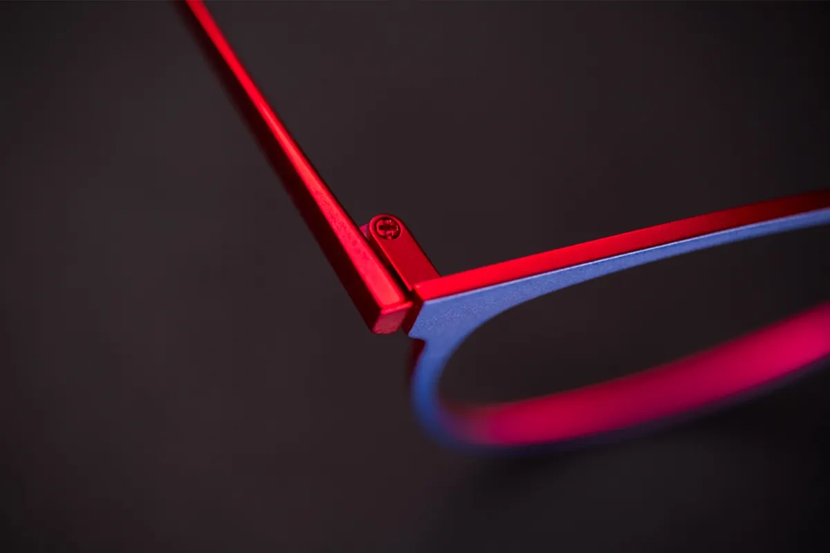 Detaljbild av en blå och röd glasögonbåge